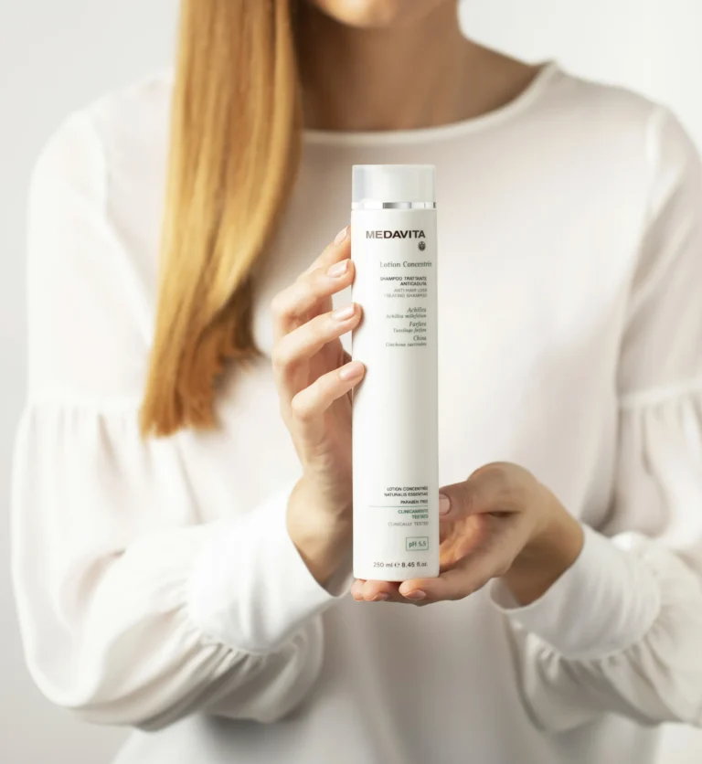 Mãos a segurar o champô Lotion Concentrée